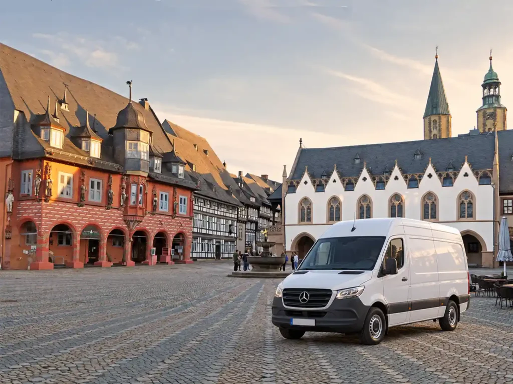 Weißer Transporter für Entrümpelung vor historischen Gebäuden am Marktplatz in Goslar