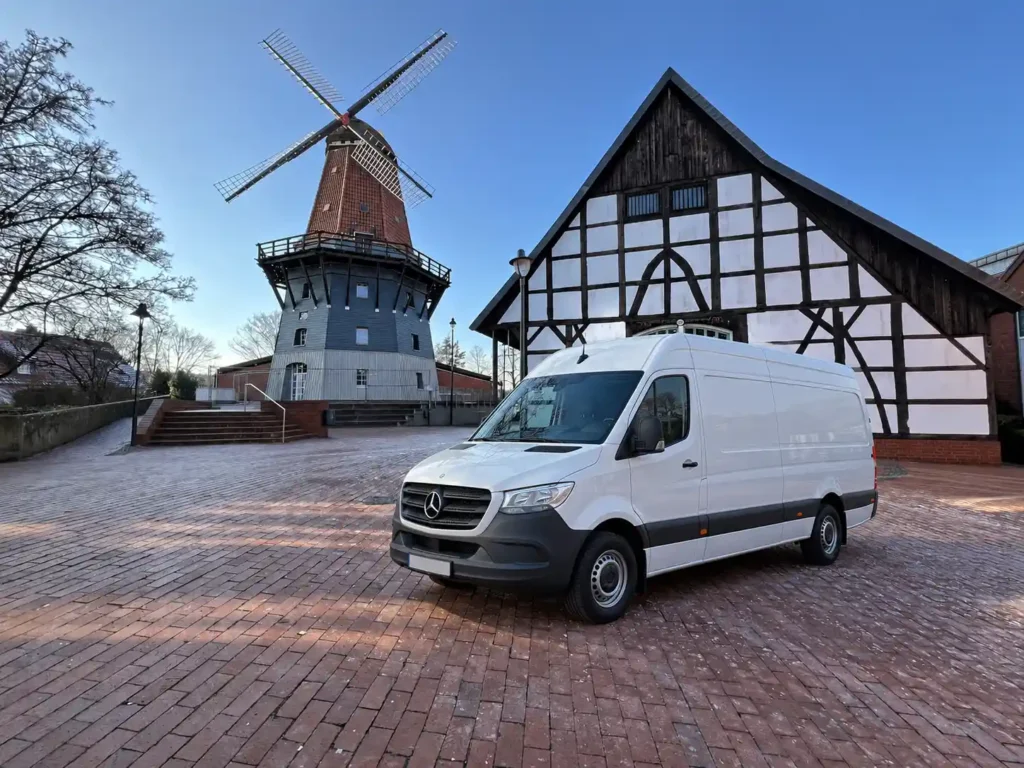 Weißer Transporter für Entrümpelung vor einer historischen Windmühle in Peine