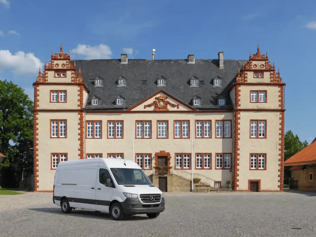 Weißer Transporter für Entrümpelung vor einem historischen Gebäude in Lengede